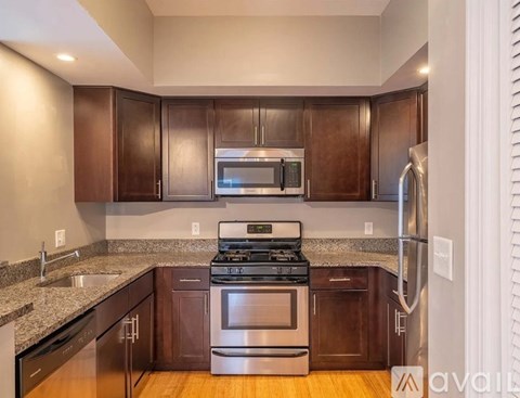 A kitchen with dark wood cabinets and stainless steel appliances.