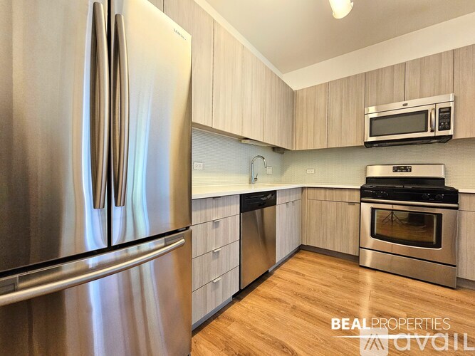 A modern kitchen with a stainless steel refrigerator and wooden cabinets.