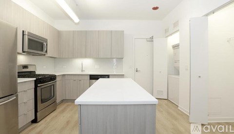 A kitchen with a white island in the middle.