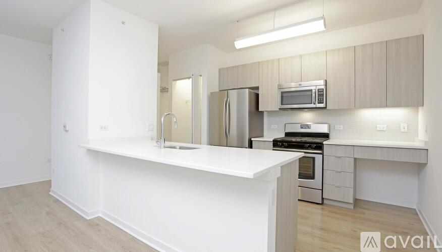A kitchen with white countertops and stainless steel appliances.