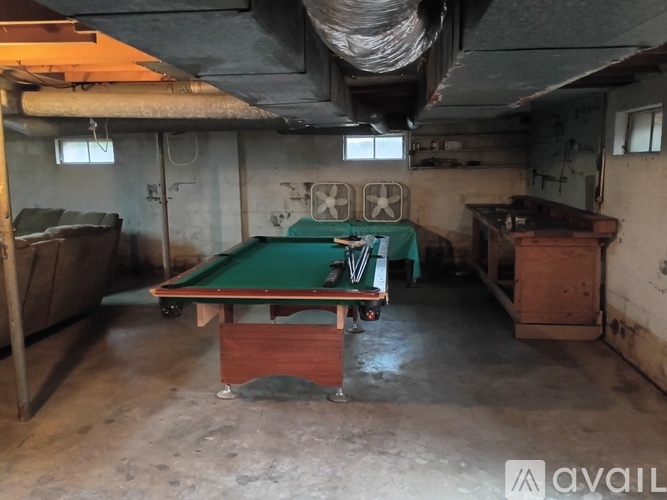 A pool table in a room with a concrete floor and walls.