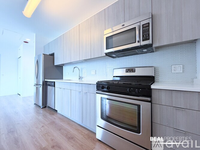 A modern kitchen with a stainless steel oven and microwave above it.