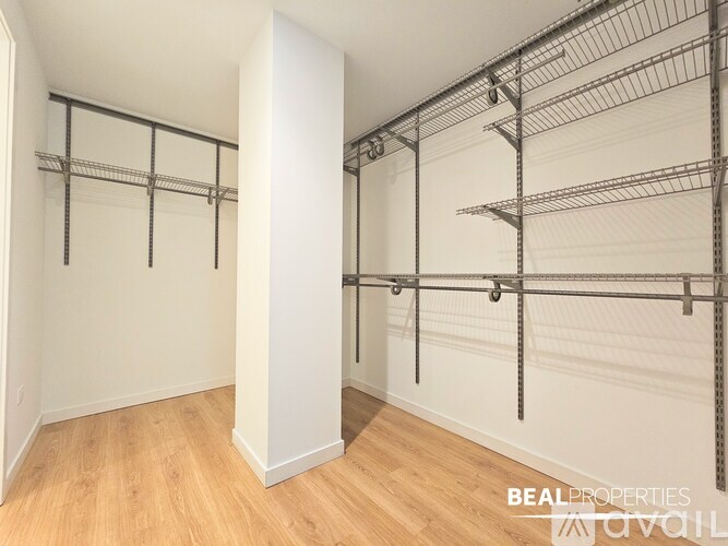 A room with a white wall and a metal shelving unit.