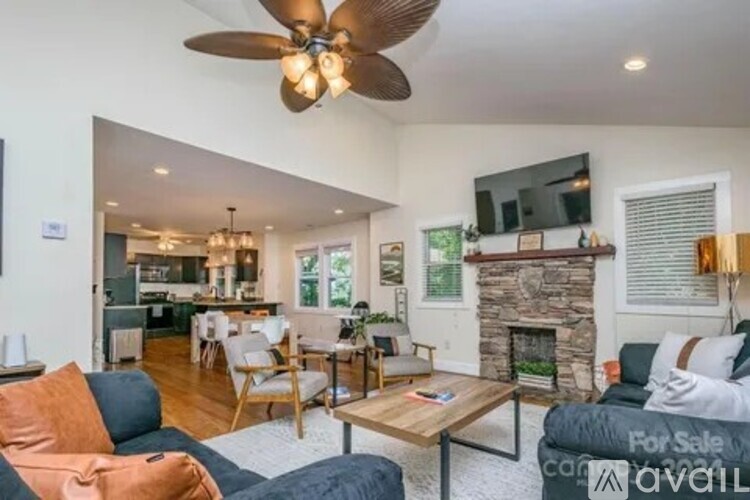 A living room with a fireplace and a television mounted above it.