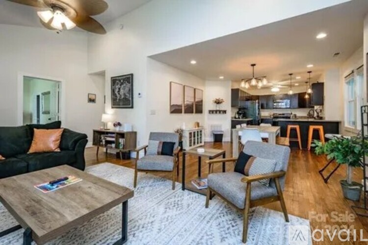 A living room with a black couch, a wooden coffee table, and a ceiling fan.