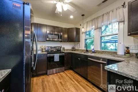 A kitchen with a refrigerator, stove, and sink is for sale.