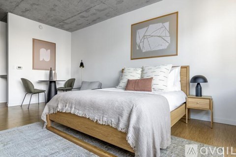 A bedroom with a large bed and a chair.