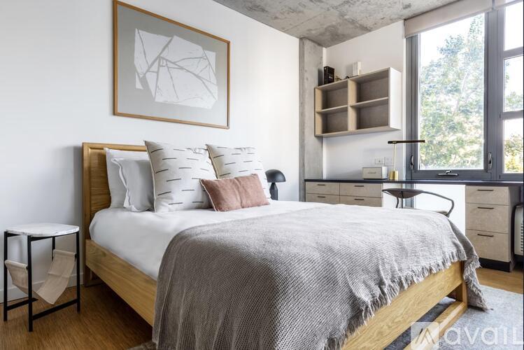 A bedroom with a bed, a nightstand, and a chair.
