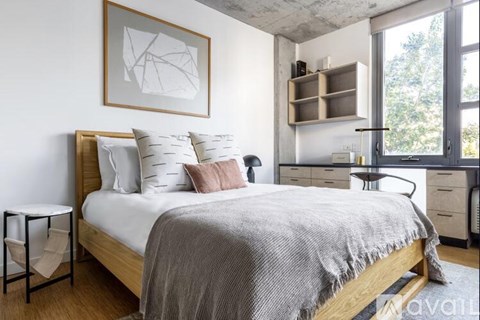 A bedroom with a bed, a nightstand, and a chair.