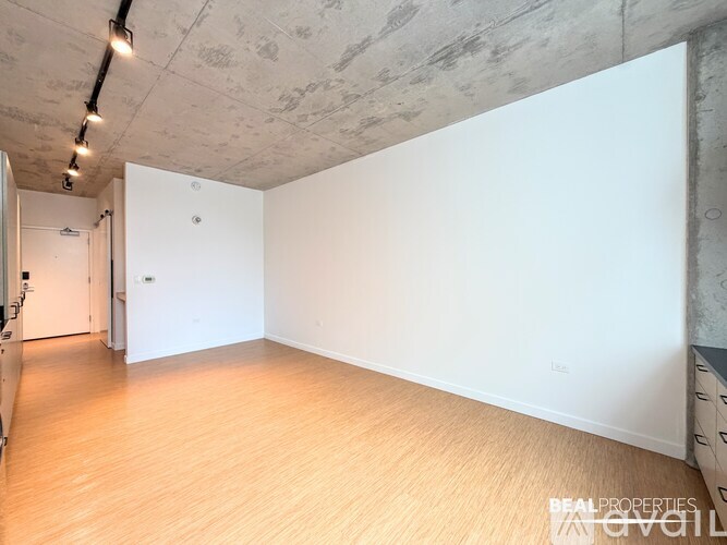 A room with a white wall and a wooden floor.