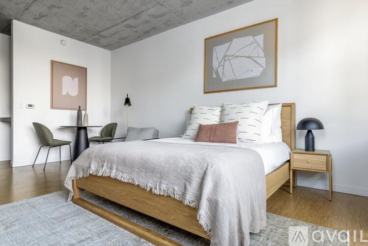 A bedroom with a large bed and a chair.