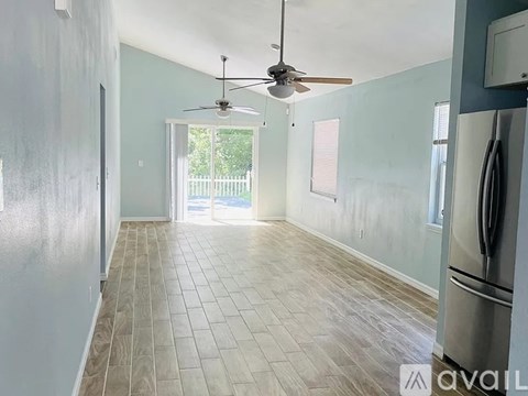 A kitchen with a fan and a fridge.