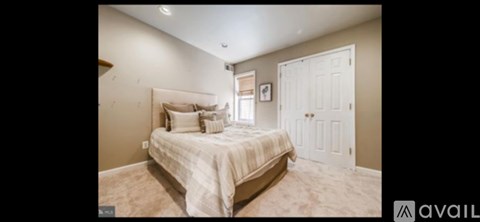 A bedroom with a large bed and a door on the right side.
