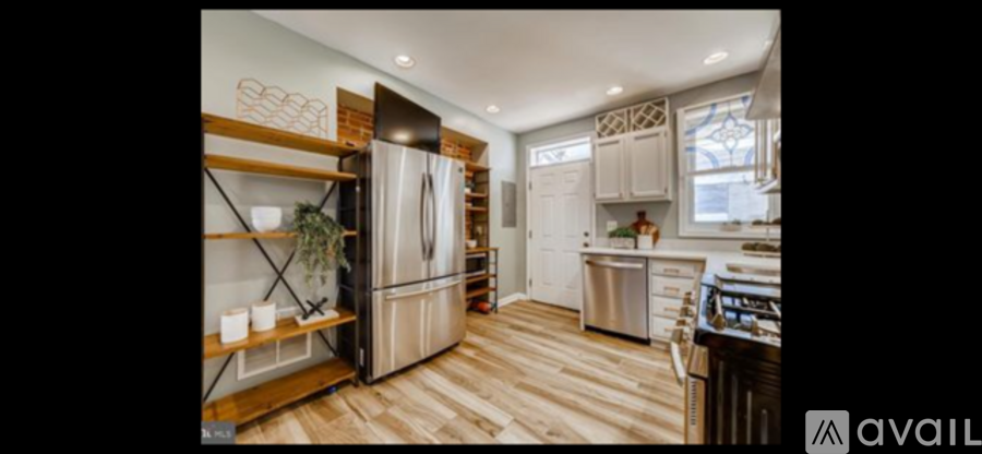 A kitchen with a wooden floor and a refrigerator with a wooden top.