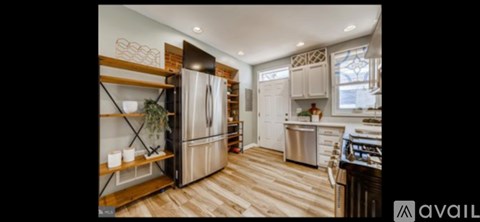 A kitchen with a wooden floor and a refrigerator with a wooden top.