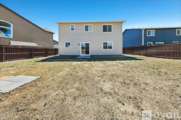 A house with a brown fence and a blue house in the background.