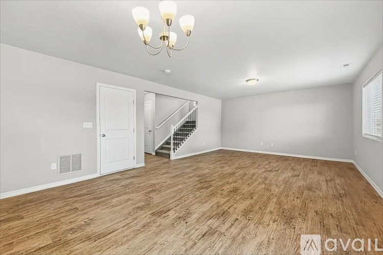 A room with wooden flooring and a chandelier.