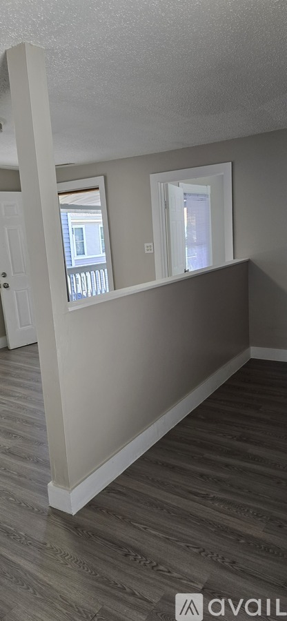 A room with a wooden floor and a window.