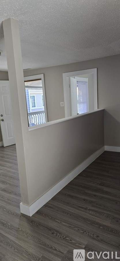 A room with a wooden floor and a window.