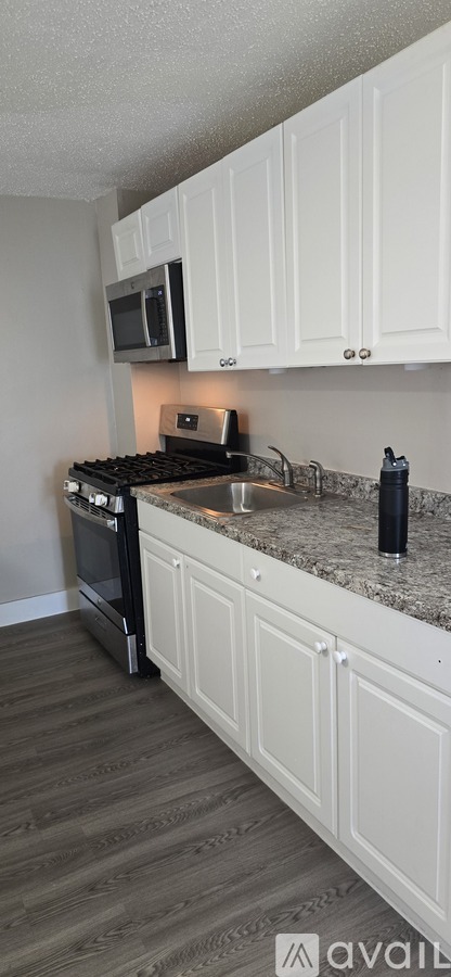 A kitchen with white cabinets and a granite countertop.