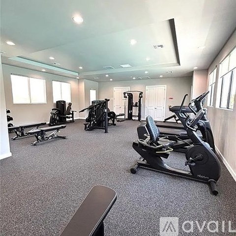 A gym with a variety of equipment including treadmills, stationary bikes, and weight machines.