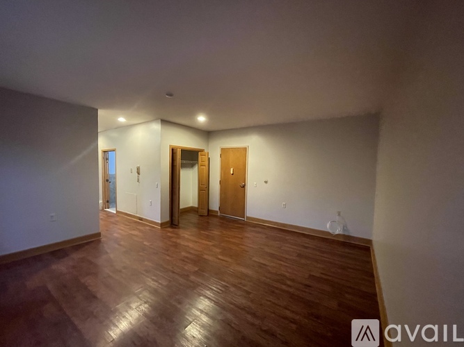 A room with wooden floors and two doors.