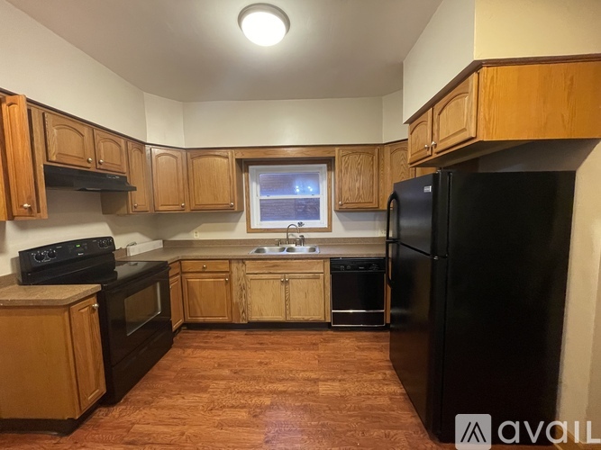 A kitchen with wooden cabinets and black appliances.