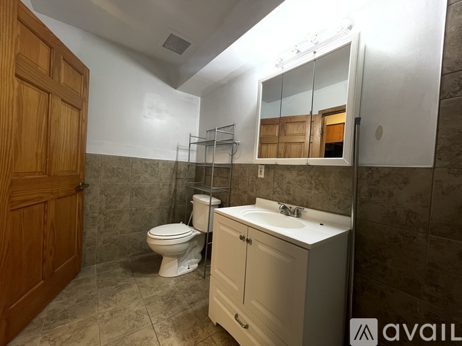 A bathroom with a toilet, sink, and mirror.