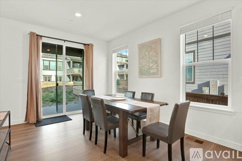 A dining room with a table and chairs and a window.
