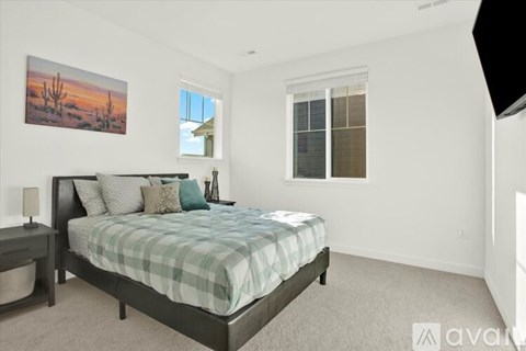 A bedroom with a bed, nightstand, and a painting on the wall.