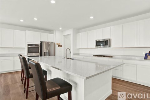 A modern kitchen with white cabinets and a central island.
