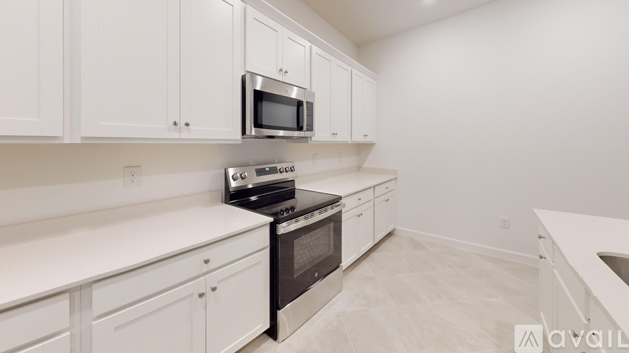 A kitchen with white cabinets and appliances.