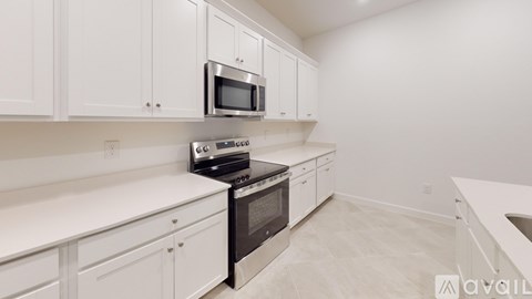 A kitchen with white cabinets and appliances.