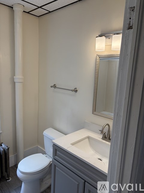 A white toilet sits next to a sink in a bathroom.
