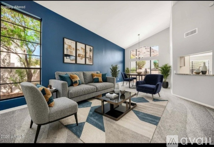A living room with a grey sofa, a grey armchair, and a coffee table.