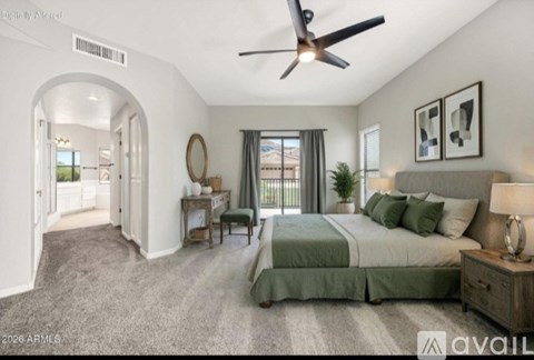 A bedroom with a large bed and a ceiling fan.