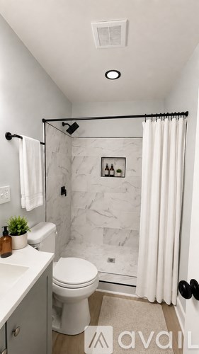 A bathroom with a toilet, sink, and shower.