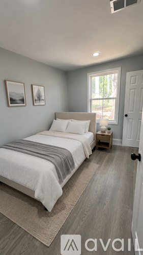 A bedroom with a bed, nightstand, and two pictures on the wall.