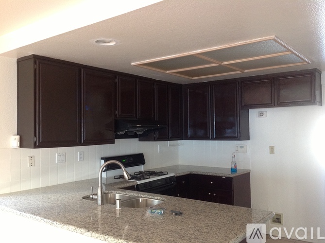 A kitchen with brown cabinets and a granite countertop.
