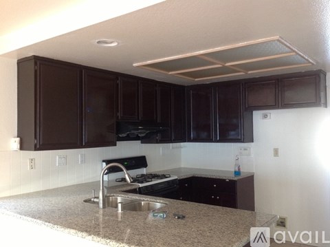 A kitchen with brown cabinets and a granite countertop.
