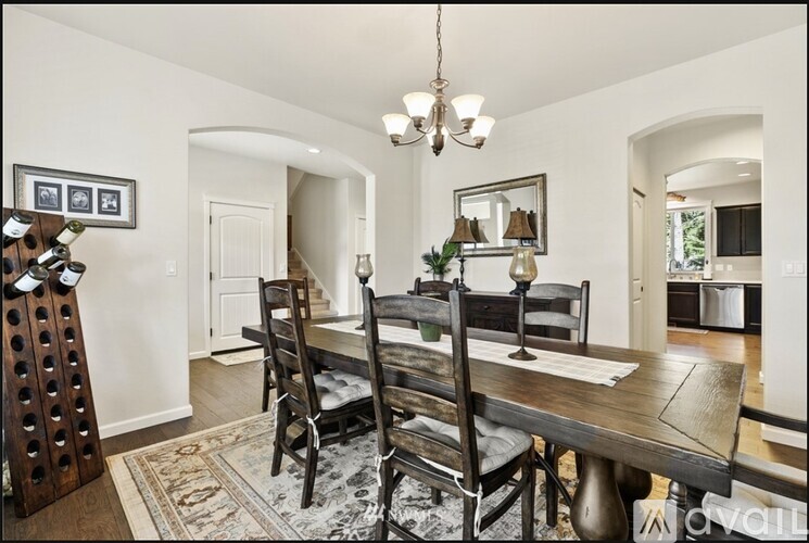 A dining room with a wooden table and chairs.