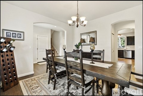 A dining room with a wooden table and chairs.