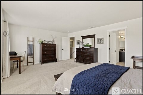 A bedroom with a large bed and a dresser.