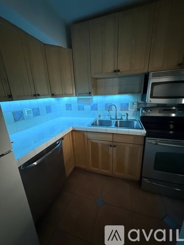 A kitchen with wooden cabinets and a black dishwasher.