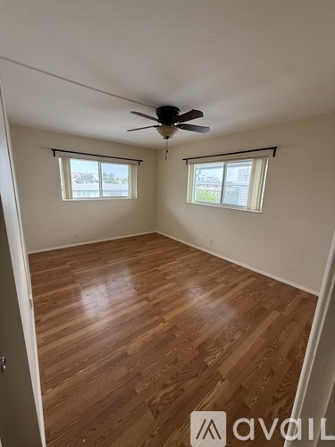 A room with wooden flooring and a ceiling fan.