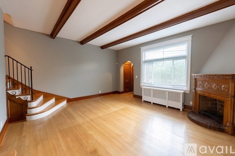 A living room with a fireplace and a staircase.