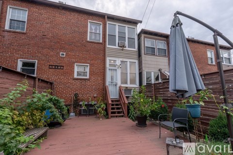 A patio with a table and chairs is in front of a brick building.