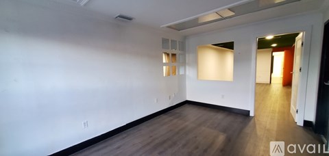 A large empty room with wooden floors and white walls.