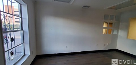 A room with a window and a wall with a switch.