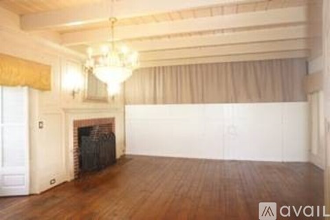 A large room with a fireplace and a chandelier.